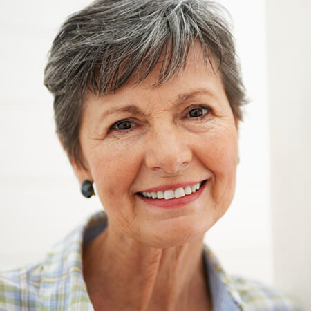 An older woman with dentures smiling