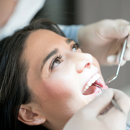 A young woman being checked by the dentist
